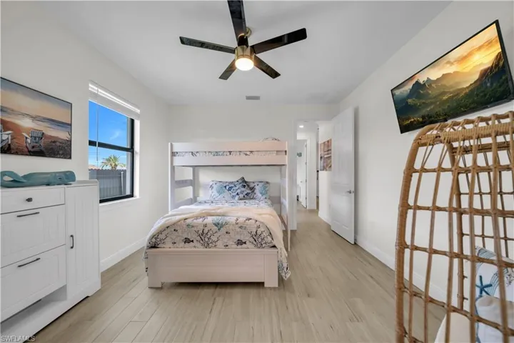 Bedroom with light wood-style flooring, baseboards, and a ceiling fan