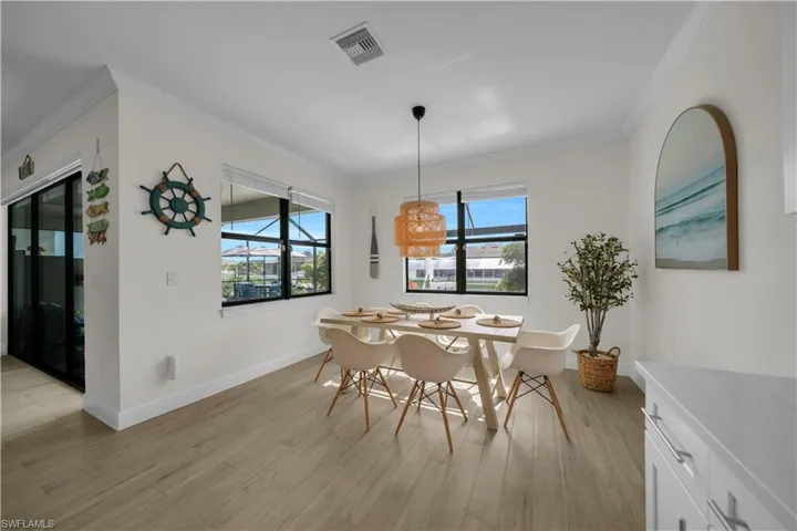 Dining room featuring crown molding, light wood-style floors, and baseboards