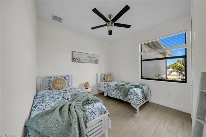 Bedroom featuring baseboards, wood finished floors, and ceiling fan