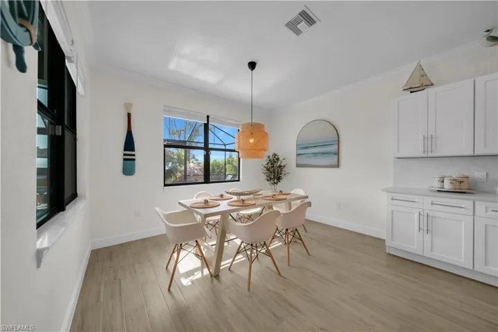 Dining space featuring light wood-style floors, baseboards, and ornamental molding