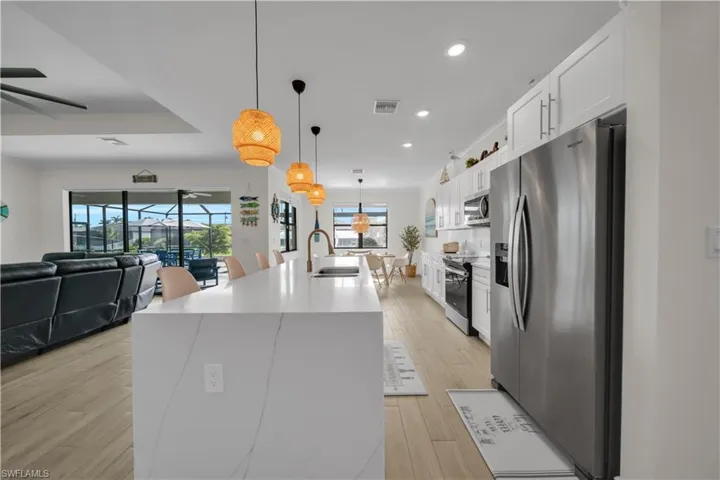 Kitchen with appliances with stainless steel finishes, a sink, ceiling fan, recessed lighting, and a kitchen island with sink