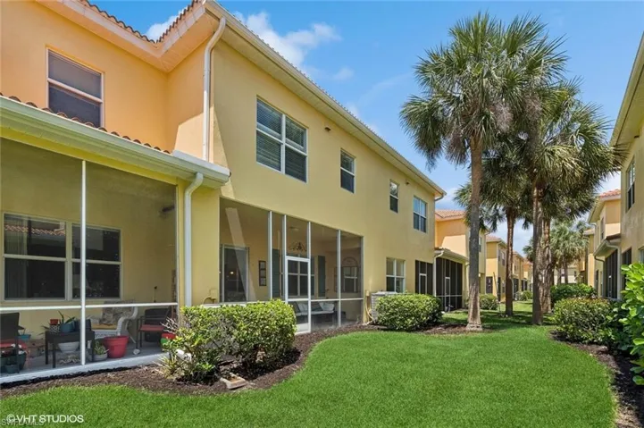 Back of property featuring a yard and a sunroom