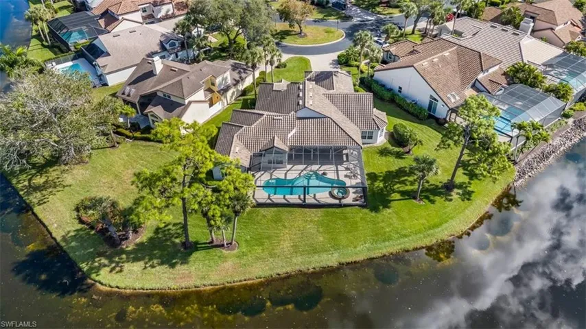Aerial perspective of suburban area featuring a large body of water and a pool area