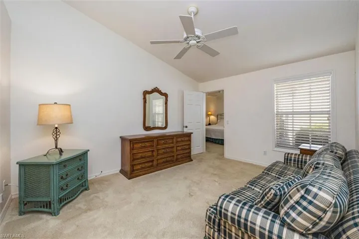 Sitting room featuring vaulted ceiling, carpet flooring, and ceiling fan