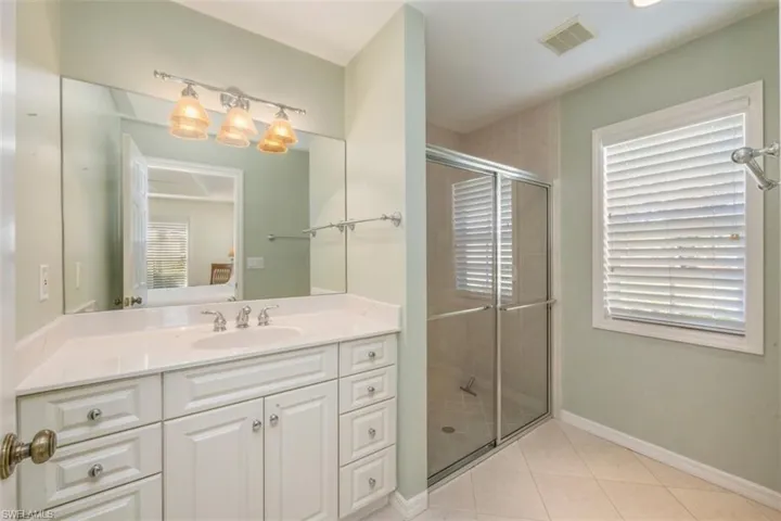 Bathroom with vanity, a shower stall, and light tile patterned flooring