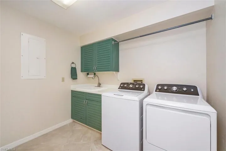 Washroom with electric panel, washing machine and dryer, and cabinet space