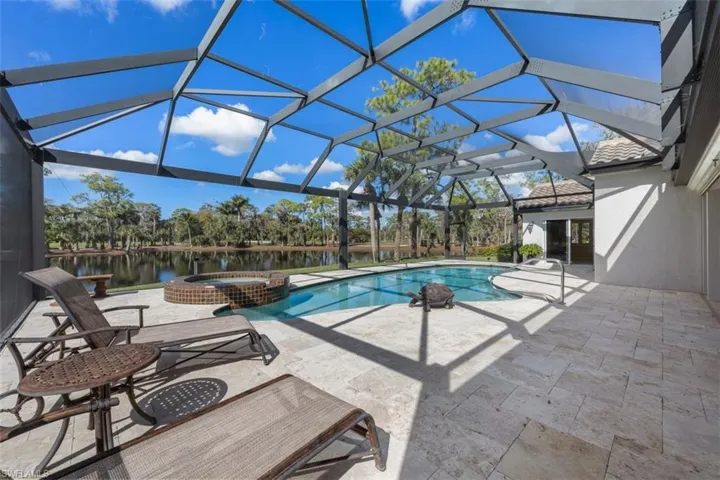 View of swimming pool with a patio, glass enclosure, a sunroom, and a pool with connected hot tub