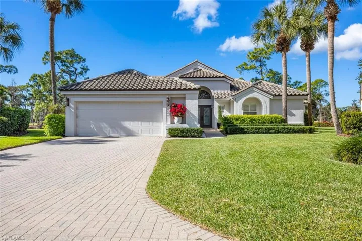 Mediterranean / spanish-style home featuring a front yard, a tile roof, stucco siding, and decorative driveway