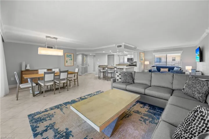 Living room with light furnishings and tile flooring.