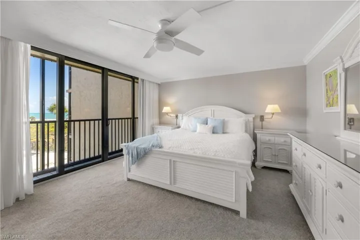 Primary bedroom with white furnishings including king size bed.