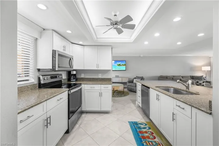 White cabinets, stainless appliances, granite counters, tile flooring.
