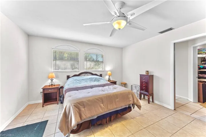 Bedroom with ceiling fan and light tile patterned flooring