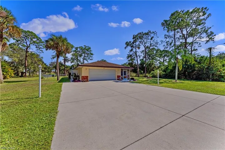 Ranch-style house with a garage and a front lawn
