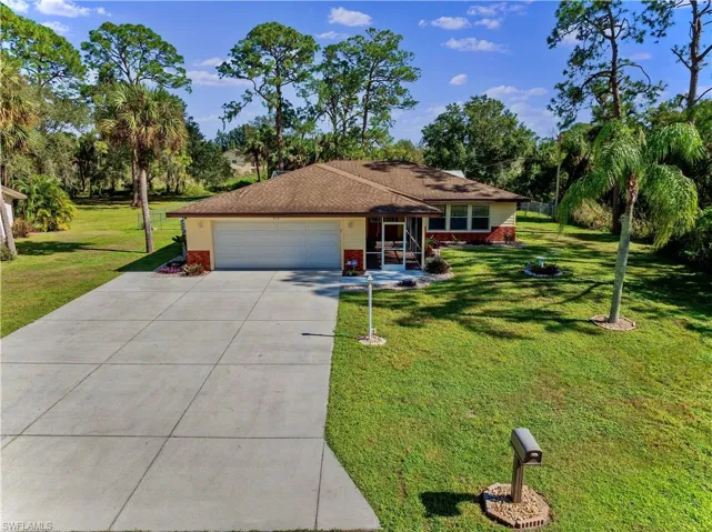 Ranch-style house featuring a front yard and a garage