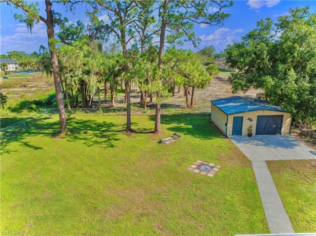 View of yard with a garage and an outbuilding