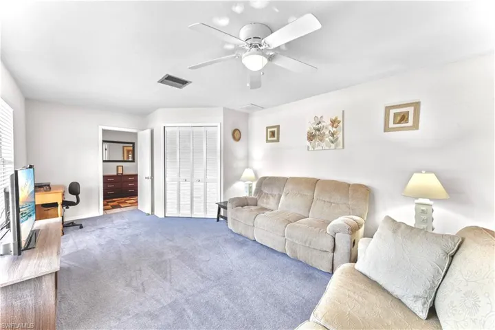 Living room featuring carpet and ceiling fan