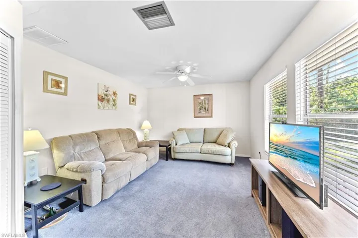 Carpeted living room with ceiling fan