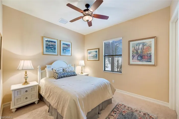 Carpeted bedroom featuring baseboards and ceiling fan