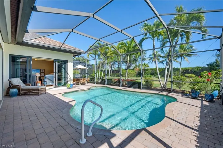 Outdoor pool with a patio, a sunroom, and a lanai
