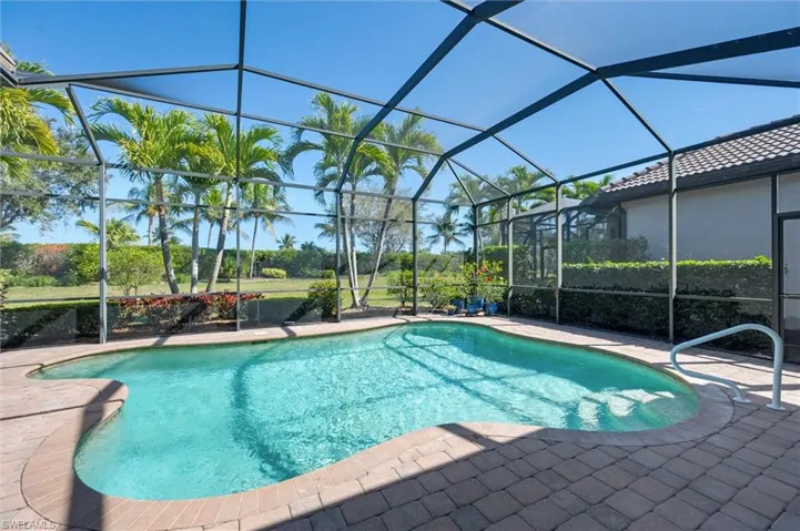 Swimming pool featuring a sunroom, glass enclosure, and a patio area