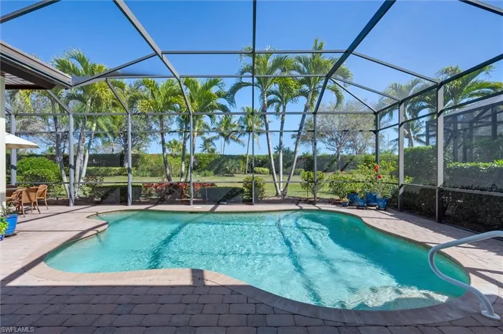 Swimming pool with a sunroom, a patio area, and glass enclosure