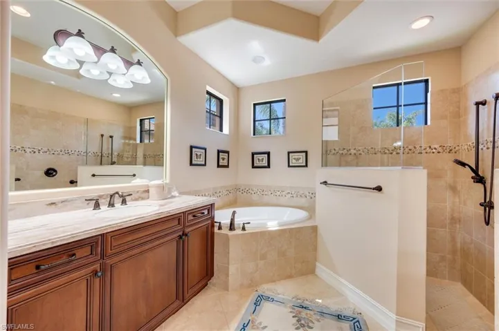 Full bathroom with walk in shower, vanity, light tile patterned floors, a garden tub, and recessed lighting