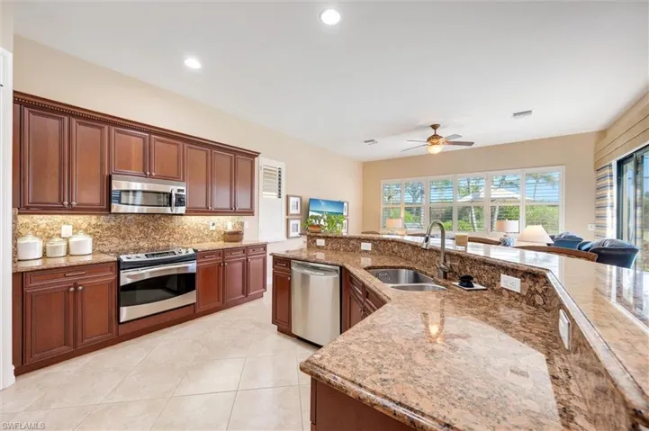 Kitchen with a ceiling fan, stainless steel appliances, light stone countertops, and recessed lighting