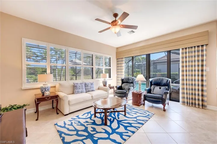 Living room with a ceiling fan and light tile patterned floors