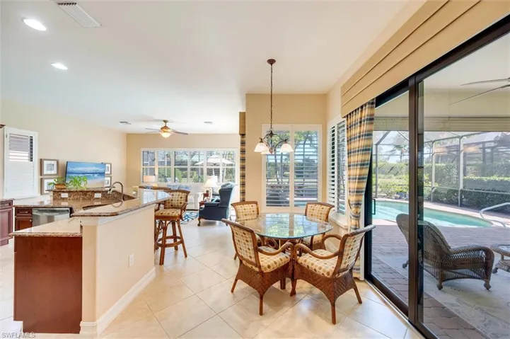 Dining space featuring ceiling fan, a sunroom, light tile patterned floors, and hanging lights