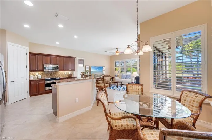 Dining area with suspended lighting, a ceiling fan, and light tile patterned flooring