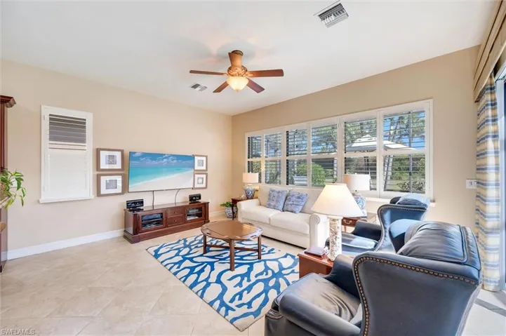 Living area with ceiling fan and light tile patterned floors
