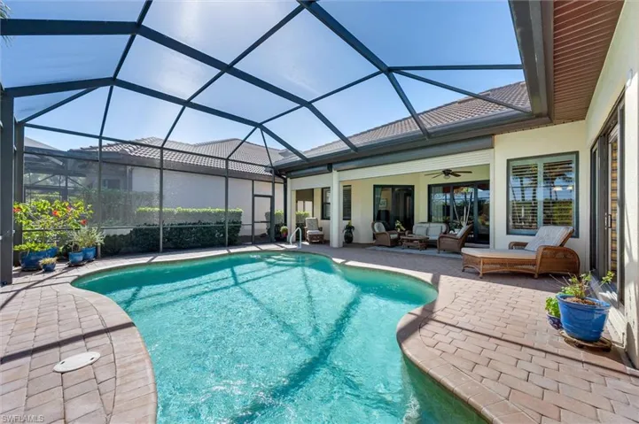 Swimming pool with a sunroom, a patio area, a lanai, and an outdoor hangout area