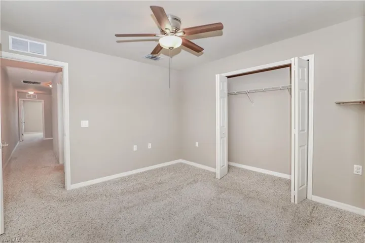Unfurnished bedroom featuring carpet flooring, a closet, a ceiling fan, and baseboards
