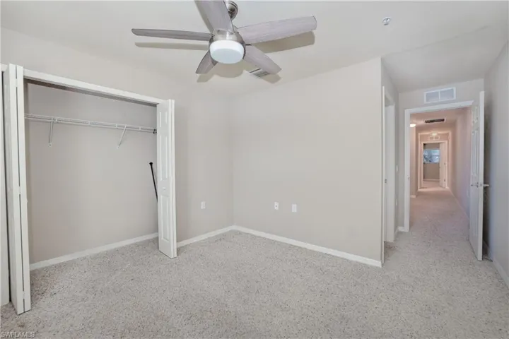 Unfurnished bedroom featuring carpet floors, a closet, ceiling fan, and baseboards