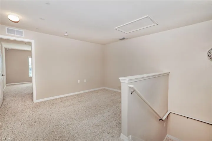 Carpeted empty room featuring baseboards