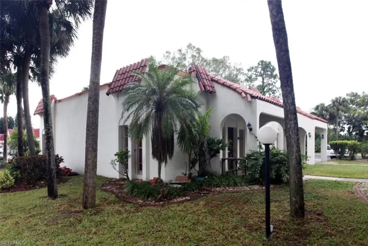 Mediterranean / spanish-style home with a tiled roof, a front yard, and stucco siding