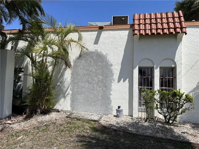 View of property exterior with a tile roof and stucco siding