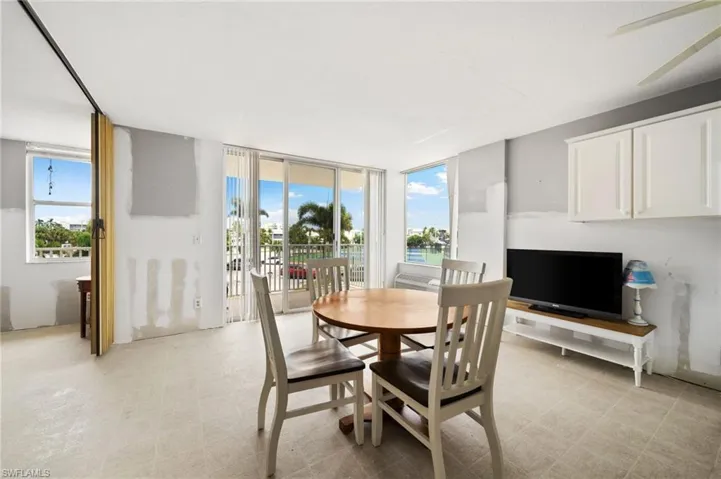 Tiled dining area featuring a wealth of natural light, floor to ceiling windows, and ceiling fan