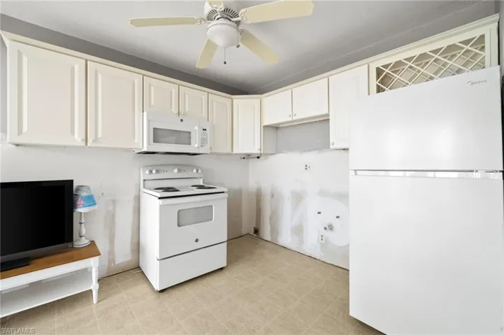 Kitchen featuring ceiling fan, white cabinetry, white appliances, and light tile patterned floors