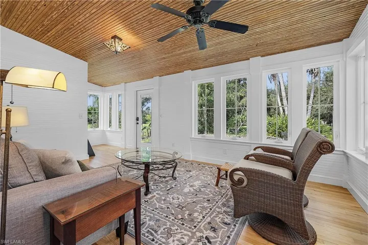 Sunroom featuring lofted ceiling, ceiling fan, and wood ceiling
