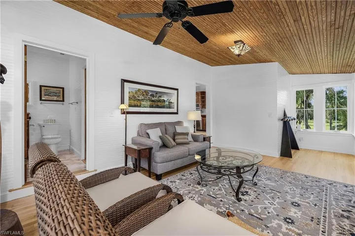 Living room with wood ceiling, ceiling fan, light wood-type flooring, and vaulted ceiling