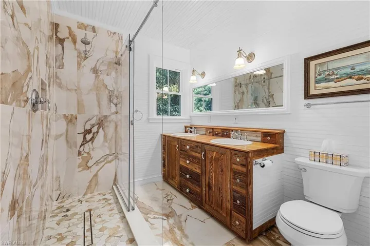 Bathroom with a shower with shower door, toilet, and vanity