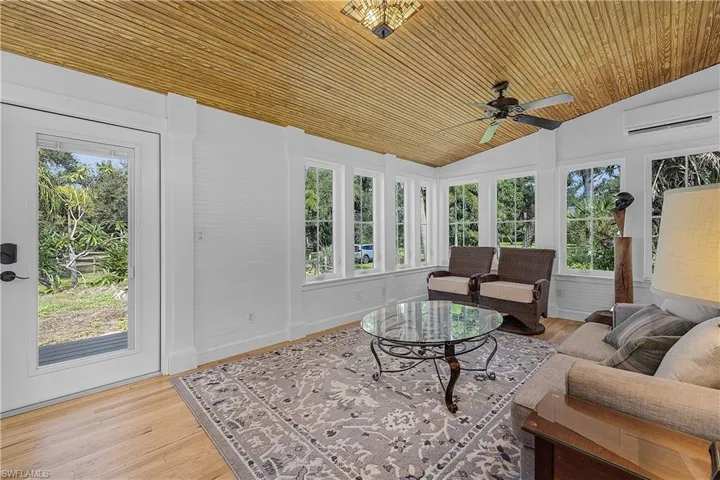 Sunroom with lofted ceiling, plenty of natural light, and ceiling fan