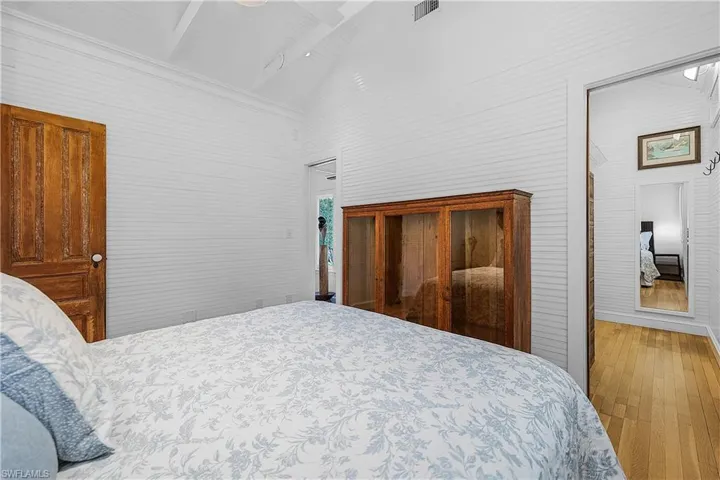 Bedroom featuring light wood-type flooring and high vaulted ceiling