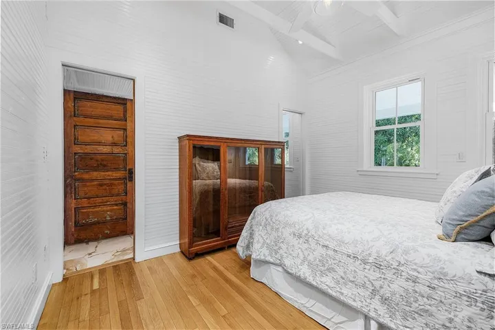 Bedroom featuring beamed ceiling, a closet, high vaulted ceiling, ceiling fan, and light wood-type flooring