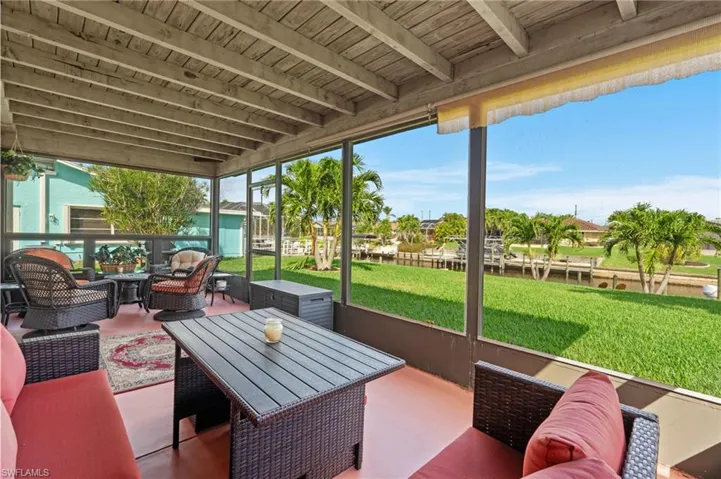 Sunroom with beamed ceiling, wooden ceiling, and a water view