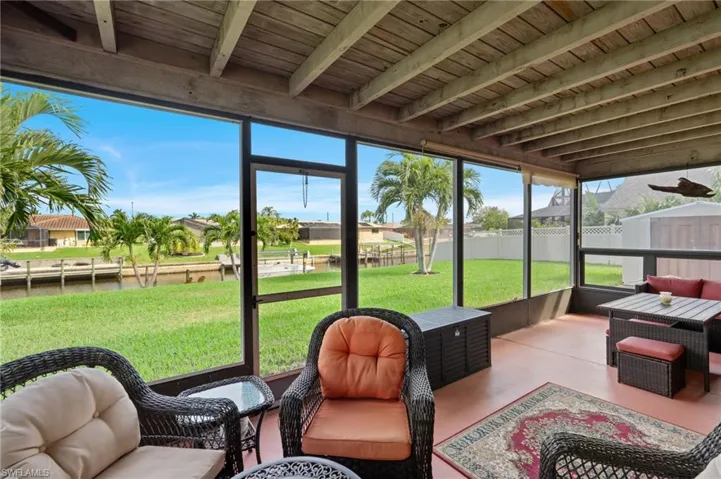 Sunroom featuring beam ceiling, a wealth of natural light, and wooden ceiling