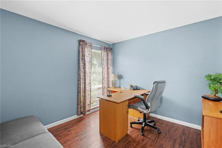 Office with dark wood-type flooring