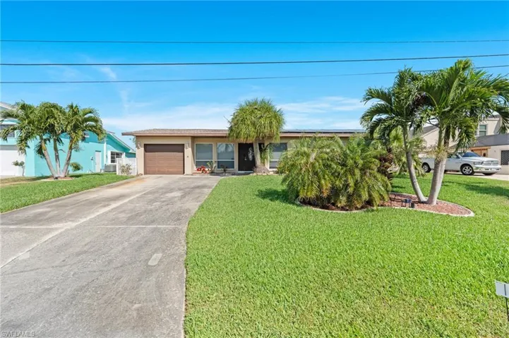 Ranch-style home with a front yard and a garage