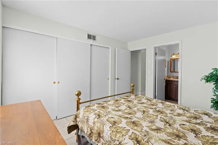 Tiled bedroom with a closet and ensuite bathroom